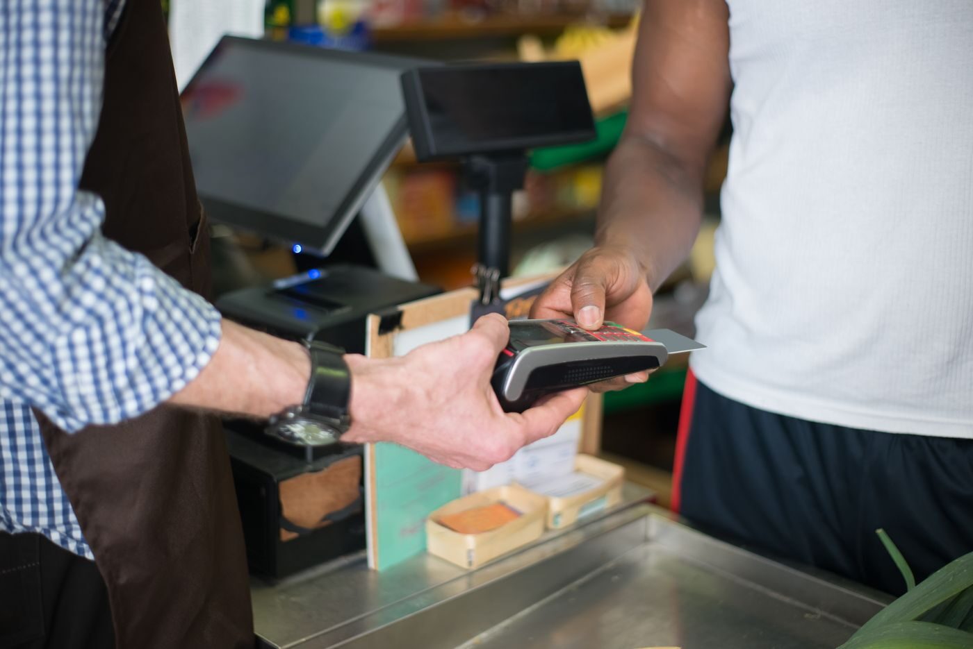 Cliente pagando com cartão em terminal TEF no balcão de uma loja